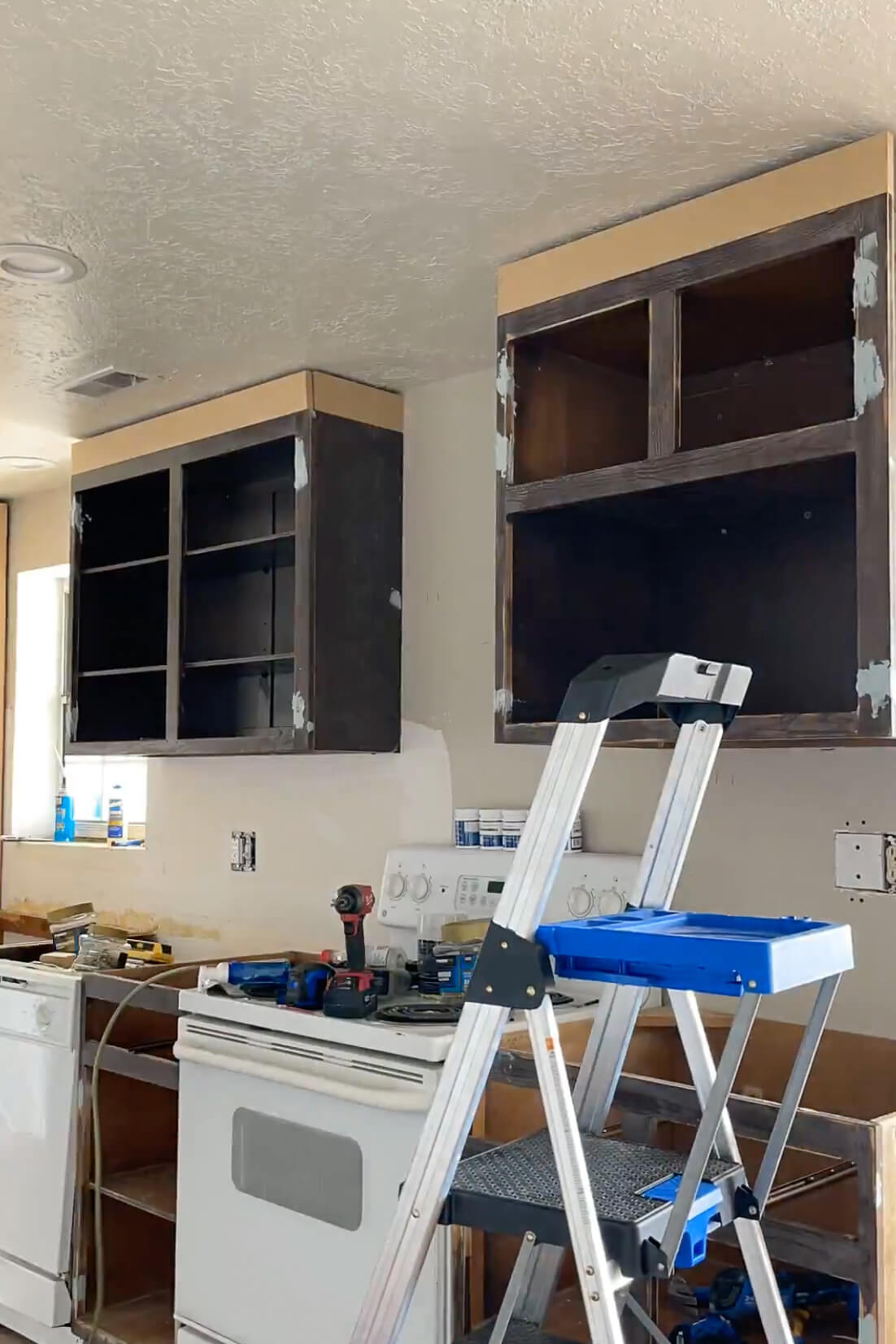 Installing crown on top of kitchen cabinets.